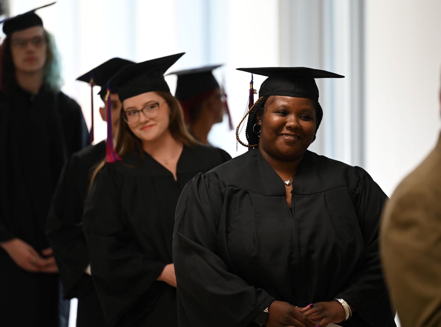 GED students lined up in cap and gown at graduation